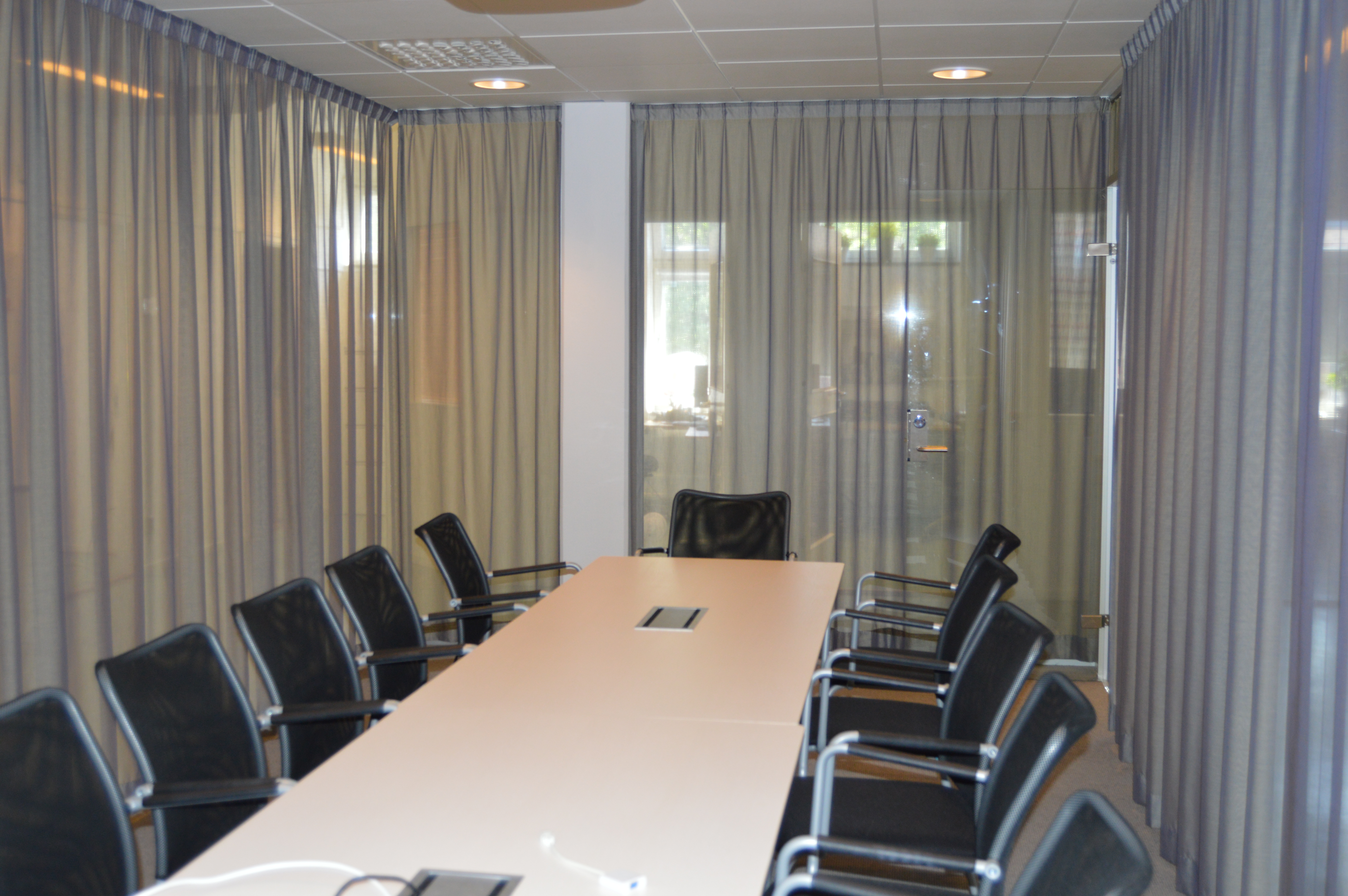 Konferensrum med stort konferensbord och plats för över tio personer.