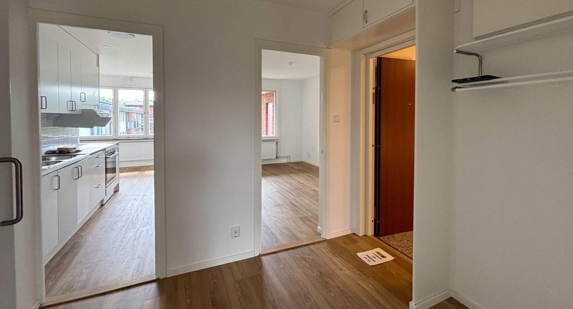 Hall med förvaring och öppningar mot kök och vardagsrum.