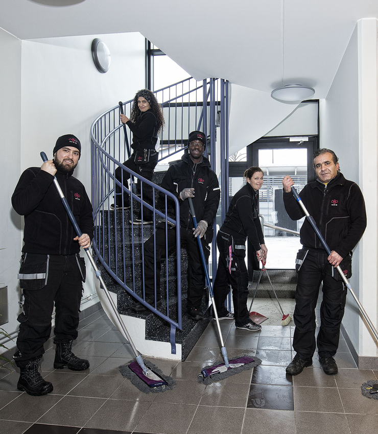 Personer ur lokalvårdsteamet städar i ett trapphus.