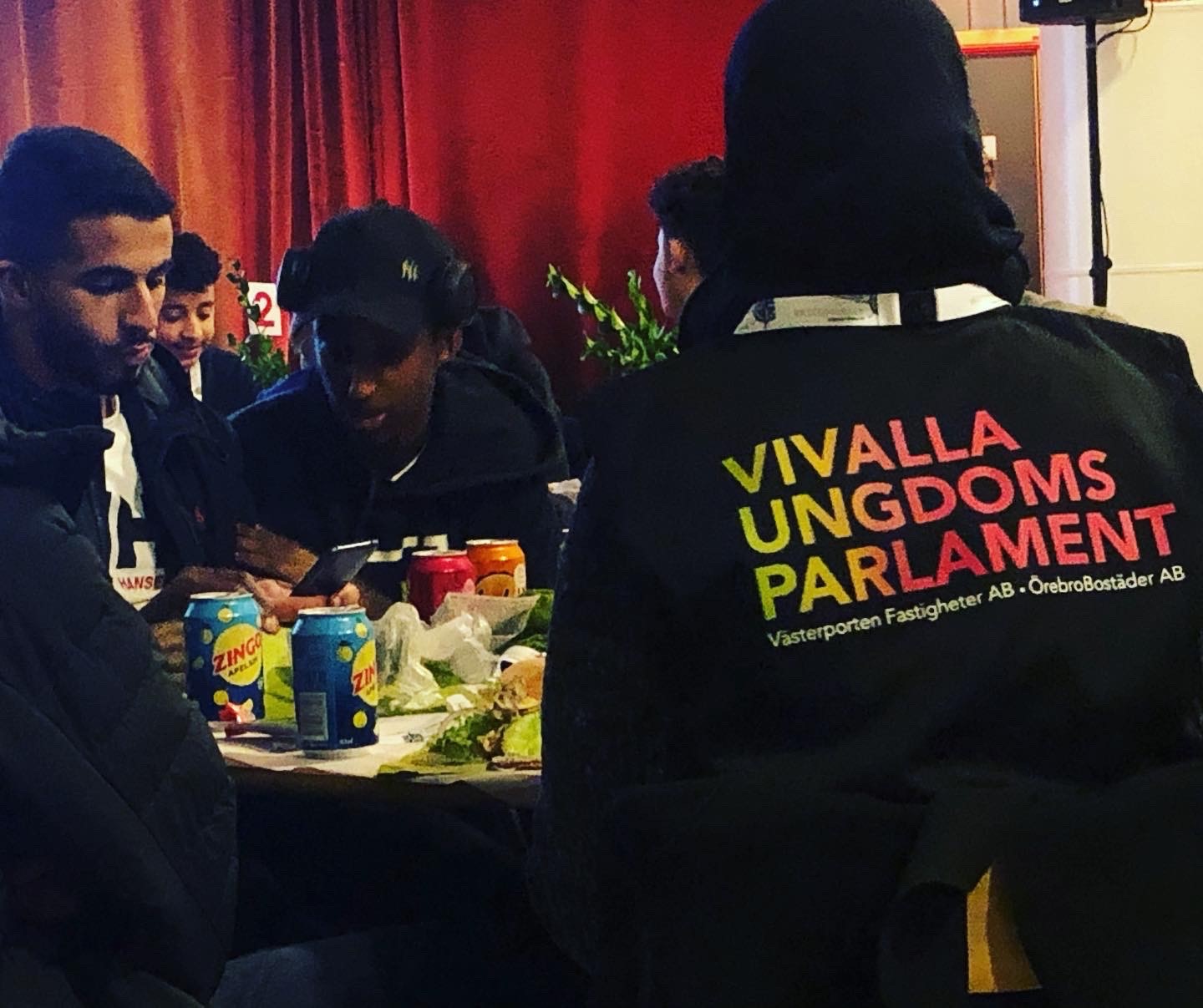 Ungdomar i Vivalla ungdomsparlament sitter runt ett bort och pratar med varandra.