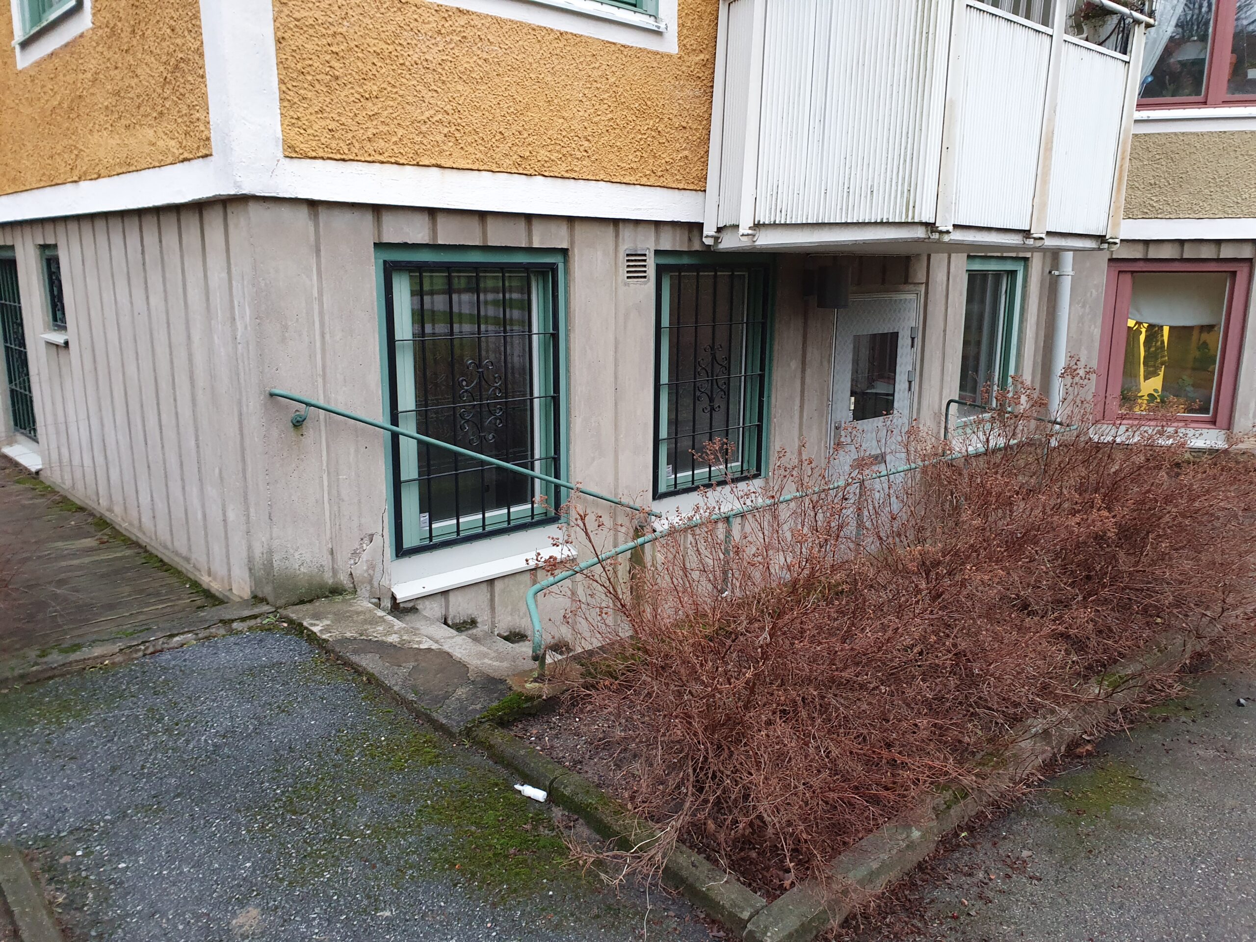 Entré till källarlokal i Rosta med egen trapp ner till dörr.