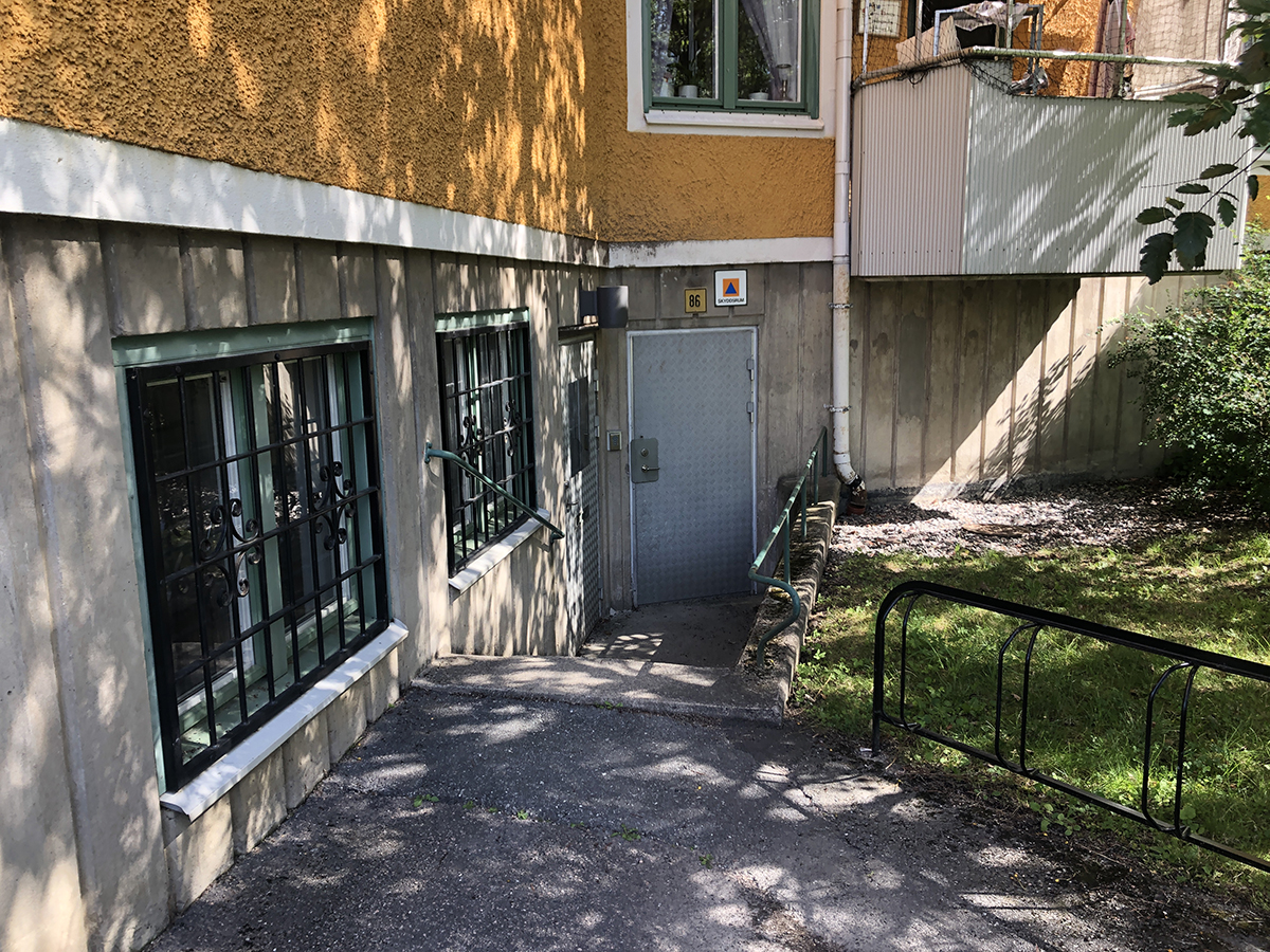 Entré till källarlokal ligger en trappa ner på sidan av huset.