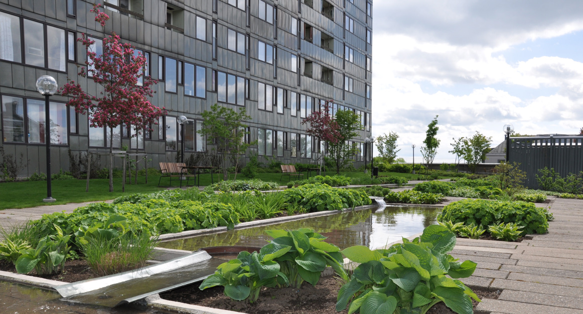 Krämarens terrass med grön växtlighet och höghus.