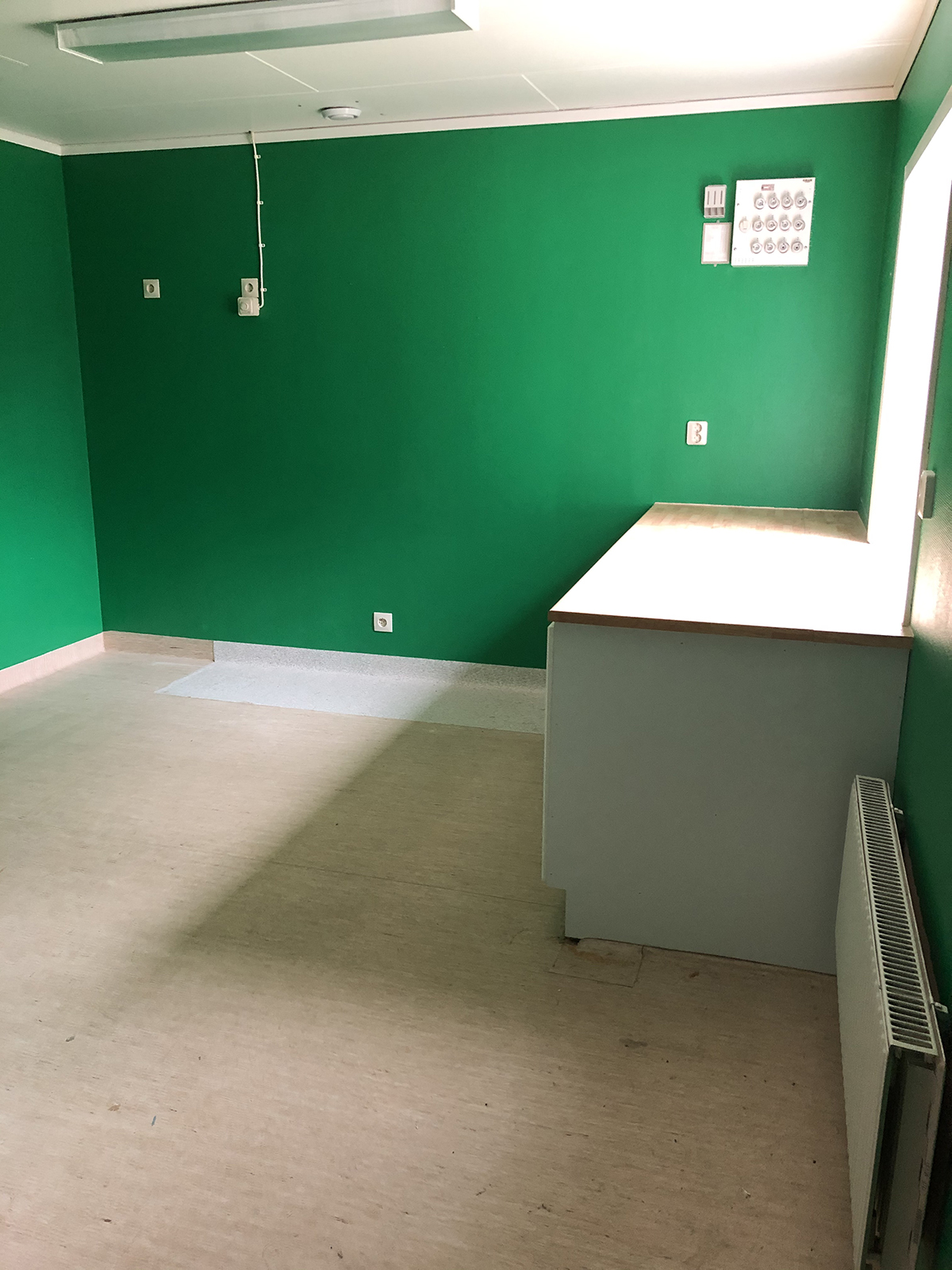 Rum med gröna väggar och en bänk