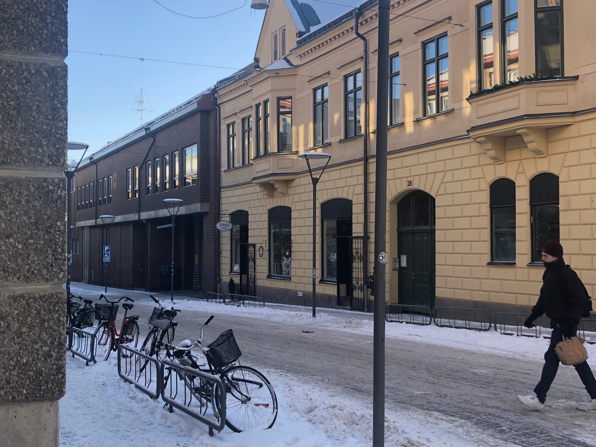 Tvåvåningshus i gammal stil, ljusgul fasad och spröjsade fönster.