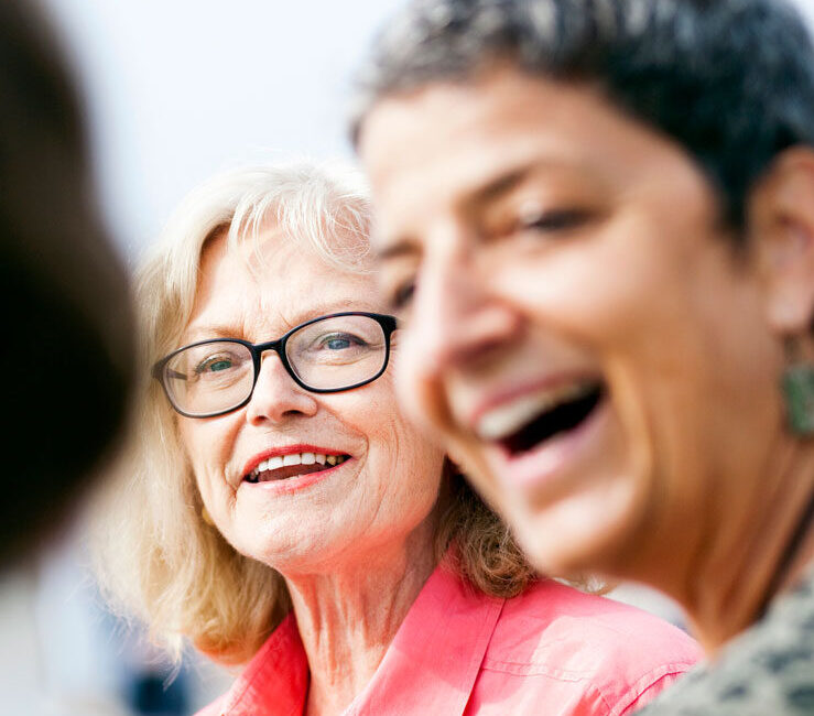 Två äldre kvinnor skrattar tillsammans.
