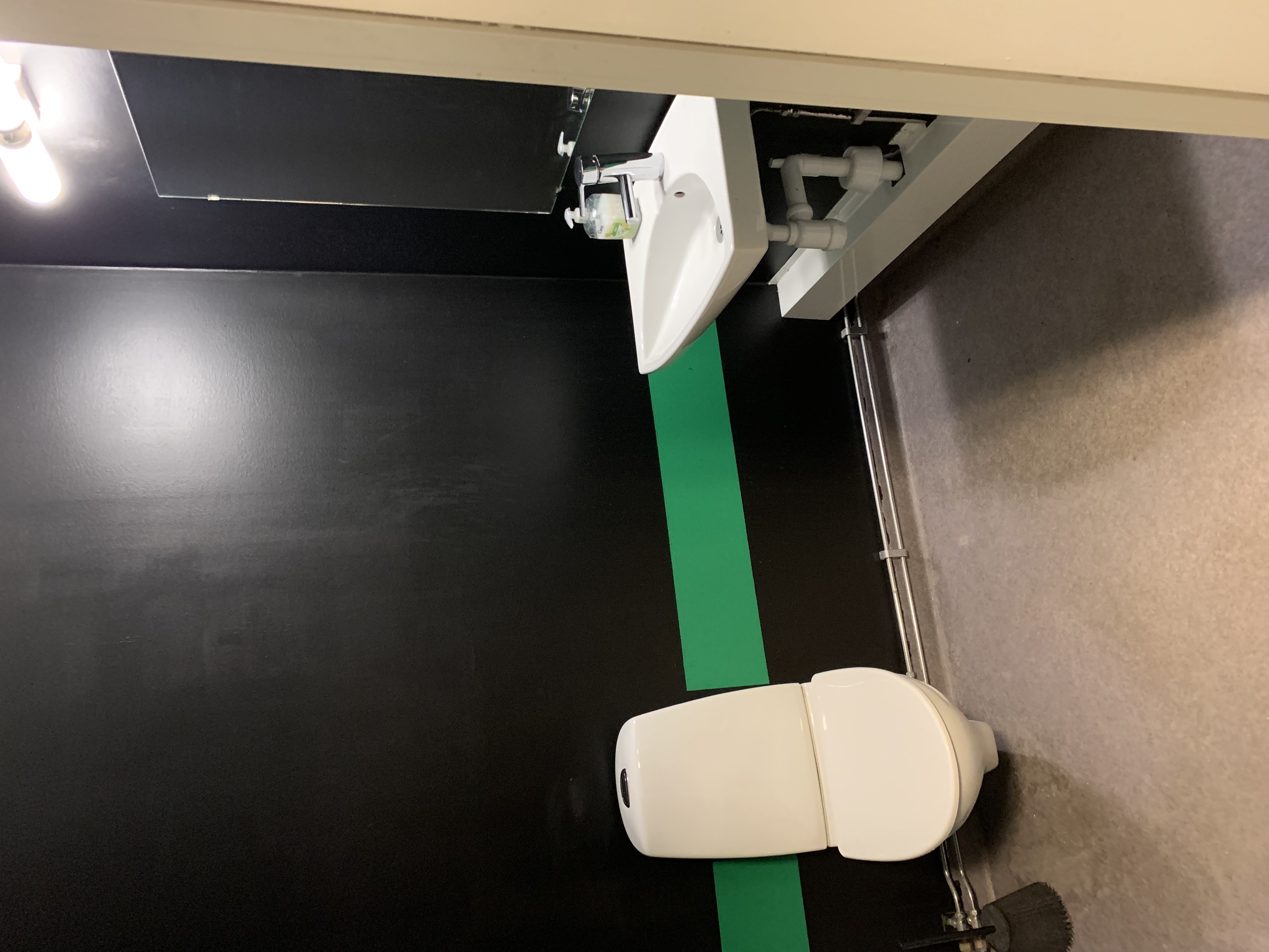 Toalett med wc-stol och handfat.