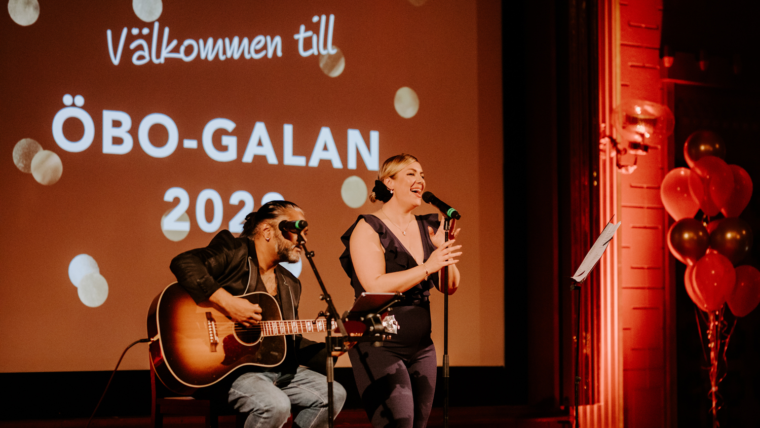 Artisten Nadine Randle sjunger tillsammans med en kompgitarrist på scenen under ÖBO-galan.