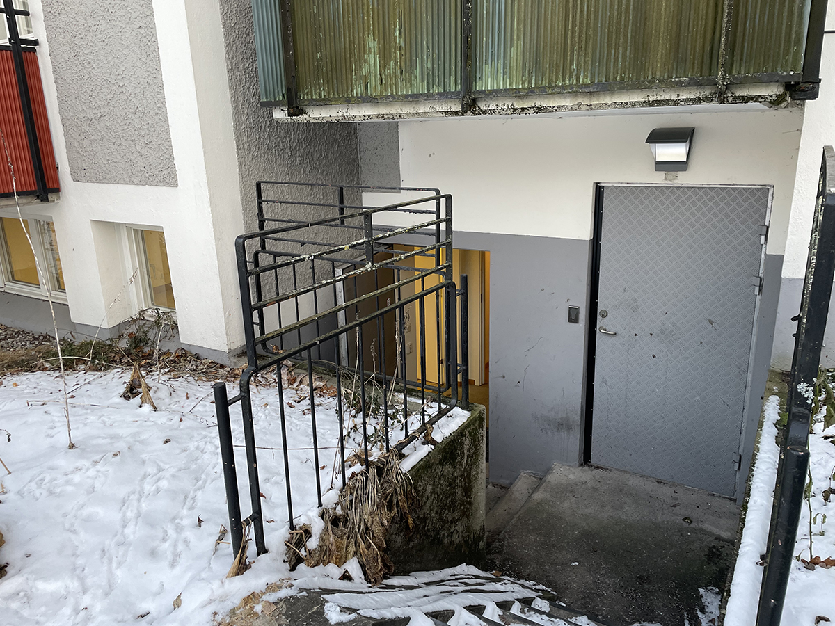 Entrén till lokalen ligger en trappa ner i ett bostadshus i Baronbackarna
