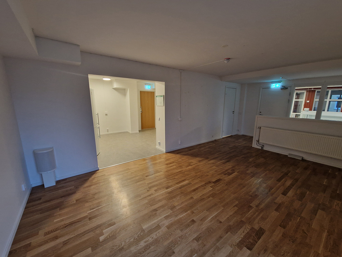 Del i lokal med större rum med vita väggar och parkettgolv