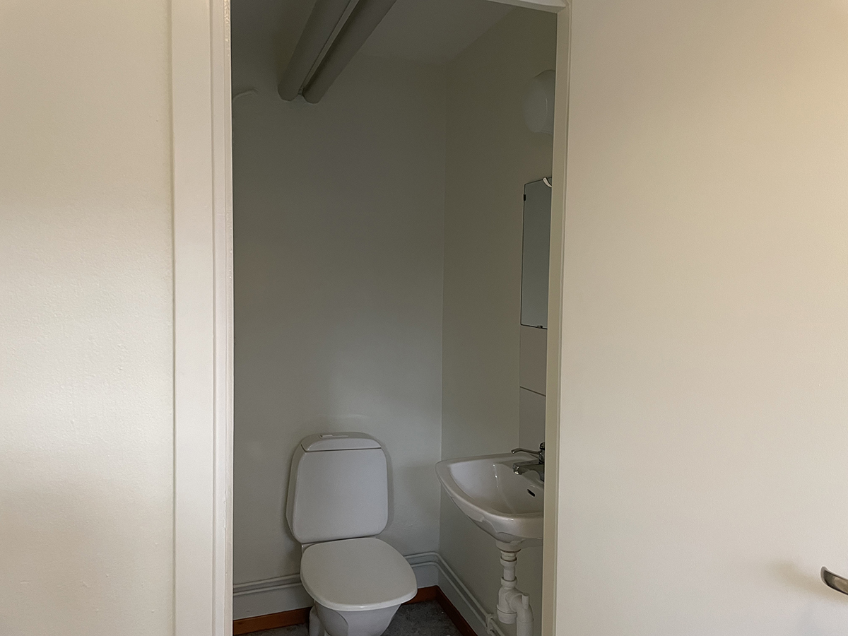 Wc med toalett, handfat och spegel