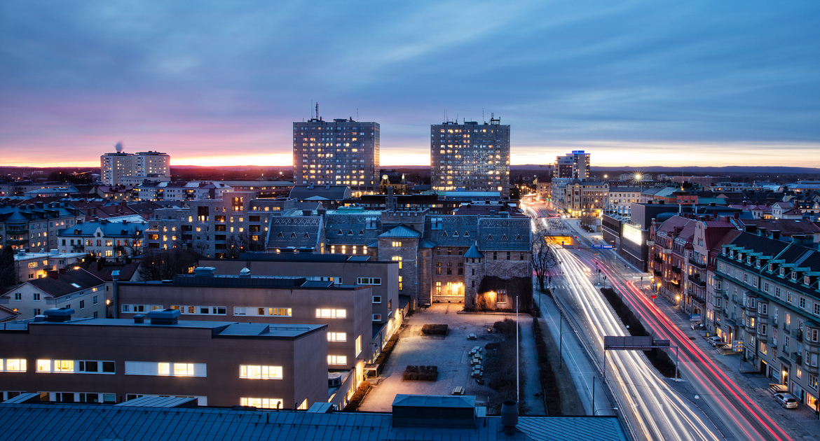 Kvällsvy över Örebro med Krämarhusen i fokus och bilar som åker längs Rudbecksgatan.