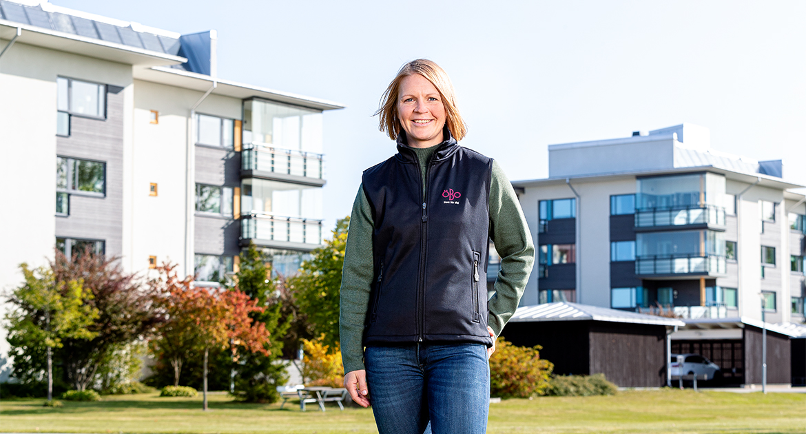 Lisa Jensen står på gräset framför ÖBOs hus på Pålsbodagatan