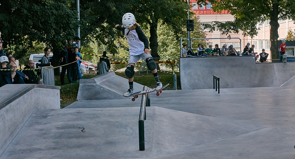 Ungdom åker skateboard på ett räcke i Örebro Skarepark.