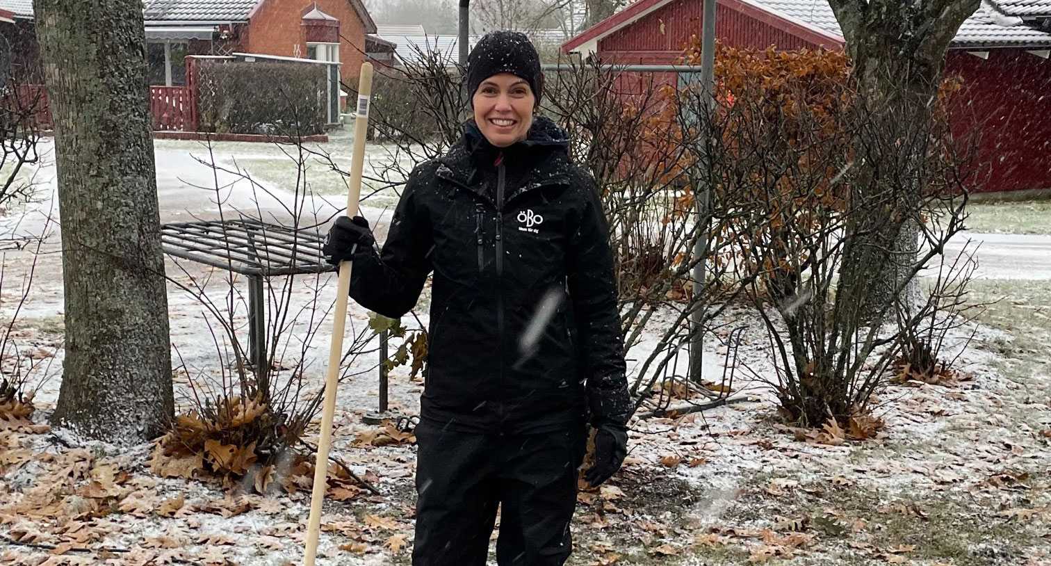 Medarbetare på ÖBO krattar löv utomhus samtidigt som det faller snö.