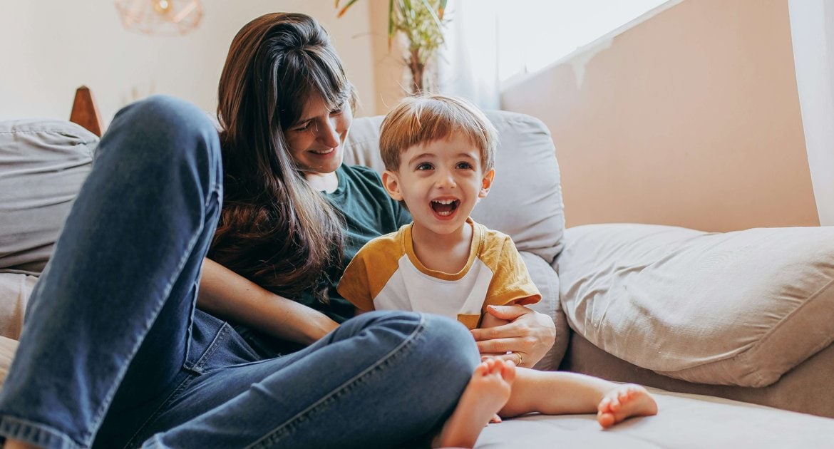 Kvinna och liten pojke sitter i sängen