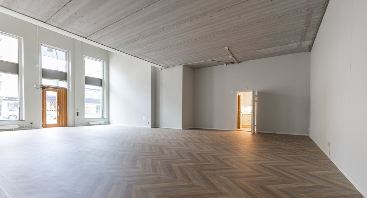 Stort rum med högt i tak och trägolv på Trädgårdsgatan 6C.