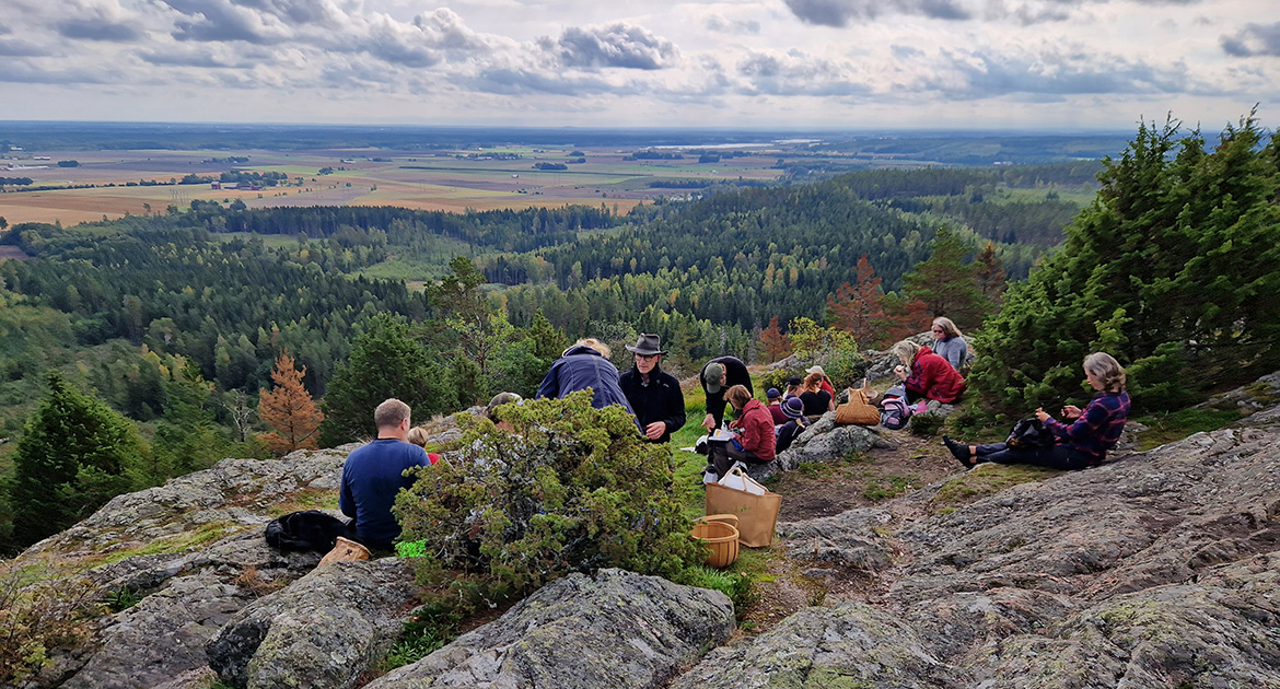 Utsikt från Ullavi klint, med grupp som fikar på klipporna
