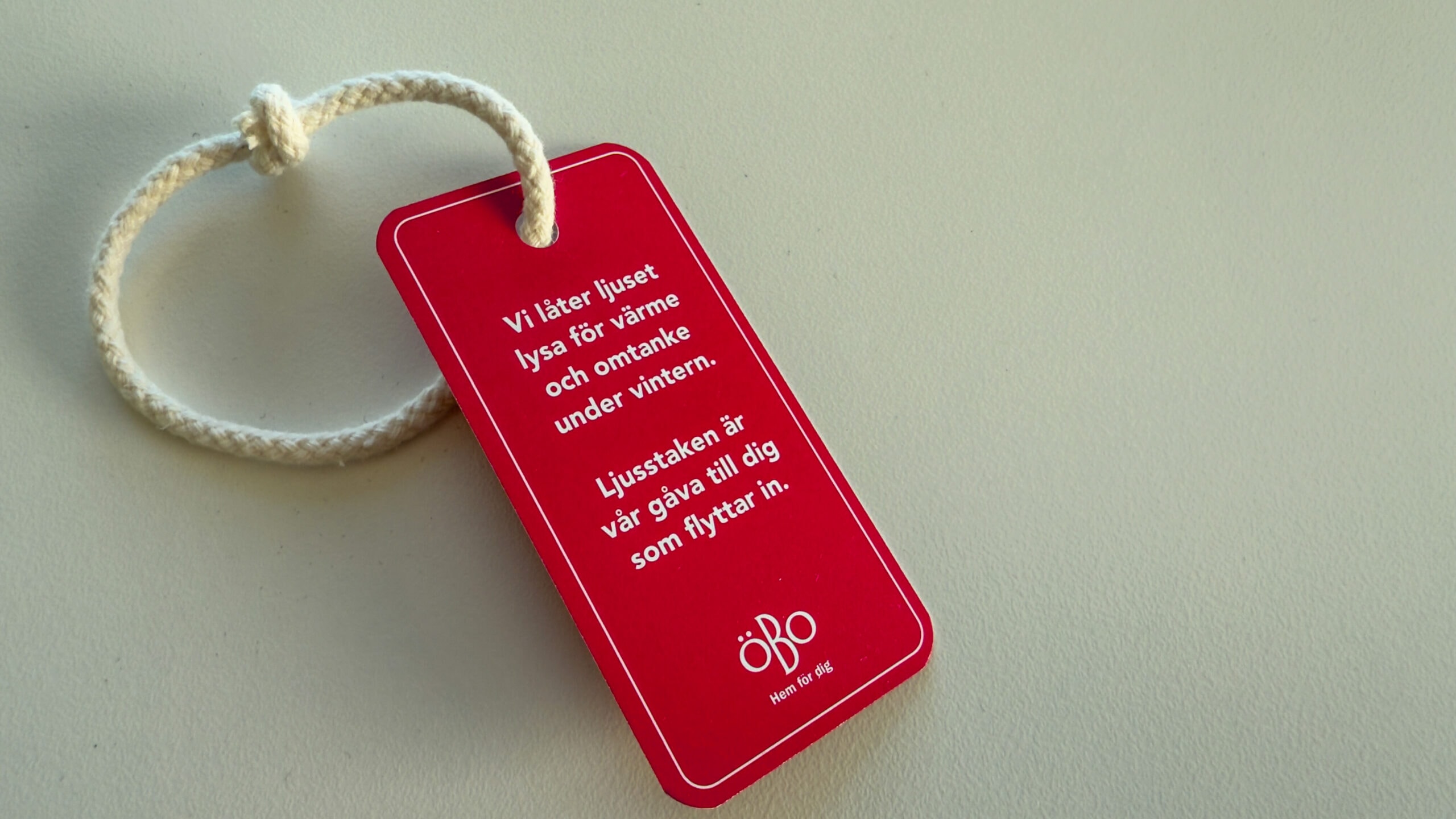 Röd etikett om att vi tänder ljusstakar för att sprida trivsel och trygghet.