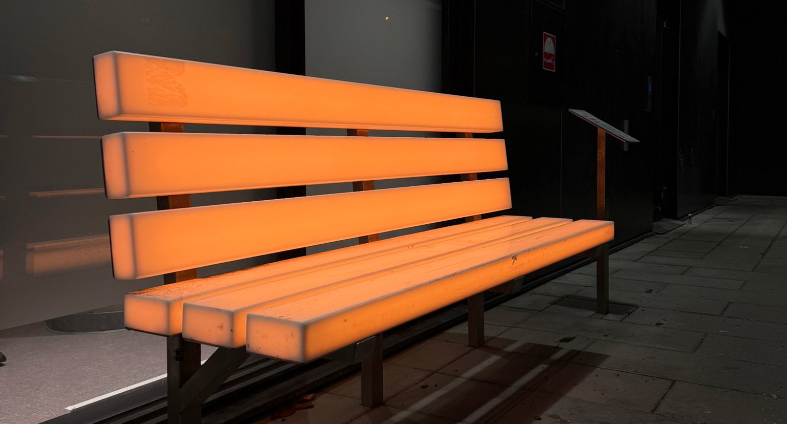 En sittbänk lyser i färgen orange.