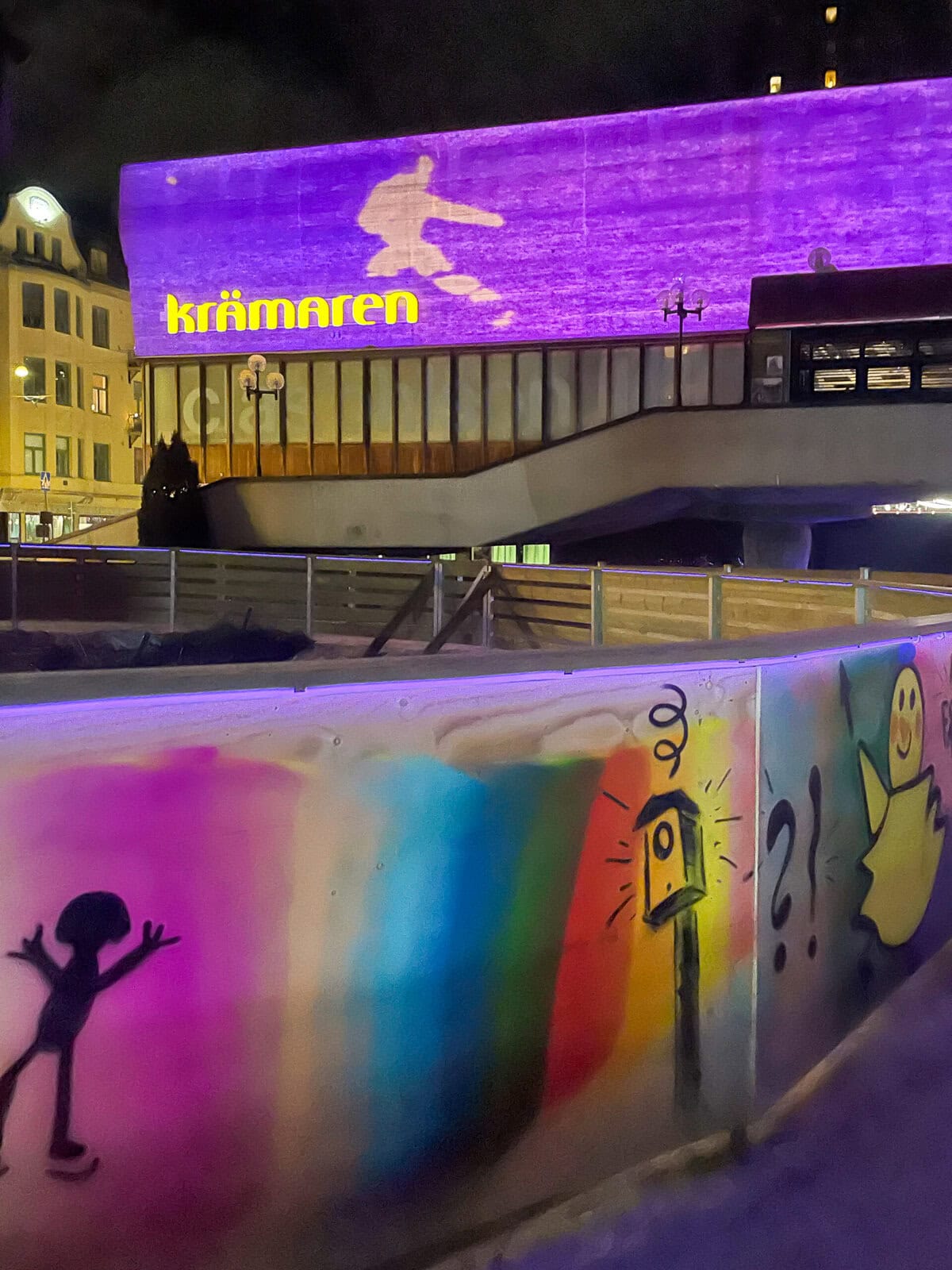 Interaktivt ljuskonstverk på Krämartorget där en skridskoåkares siluett projiceras på väggen som lyser i lila.