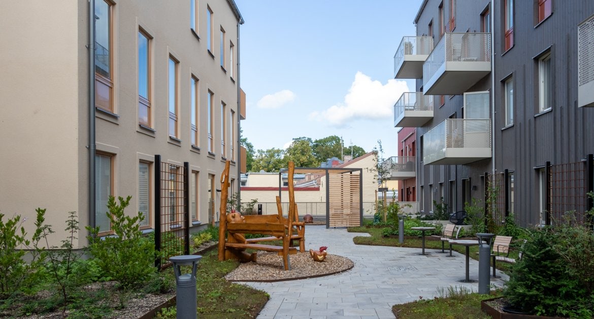 Innergård med grönska och sittplatser i kvarteret Hållstugan