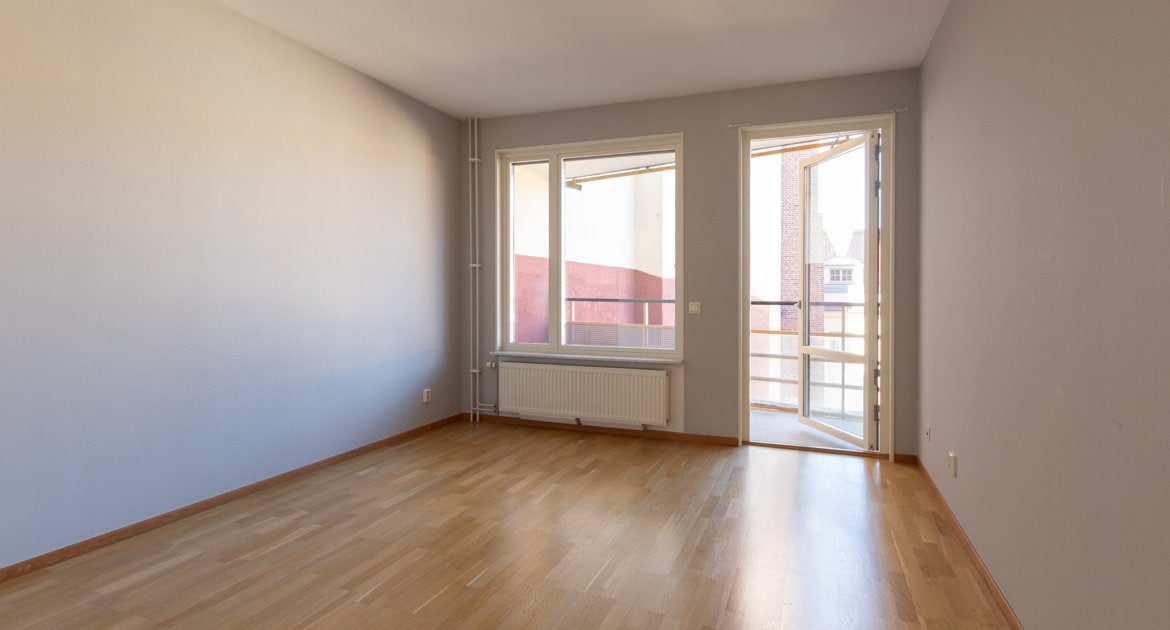 Sovrum med fönster och balkongdörr.