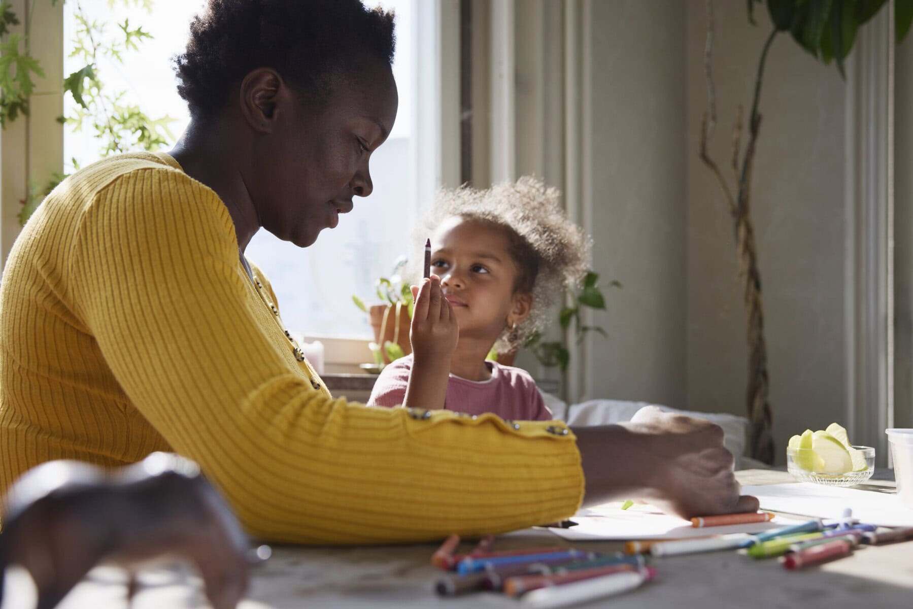 Mamma och barn i lägenhet ritar tillsammans